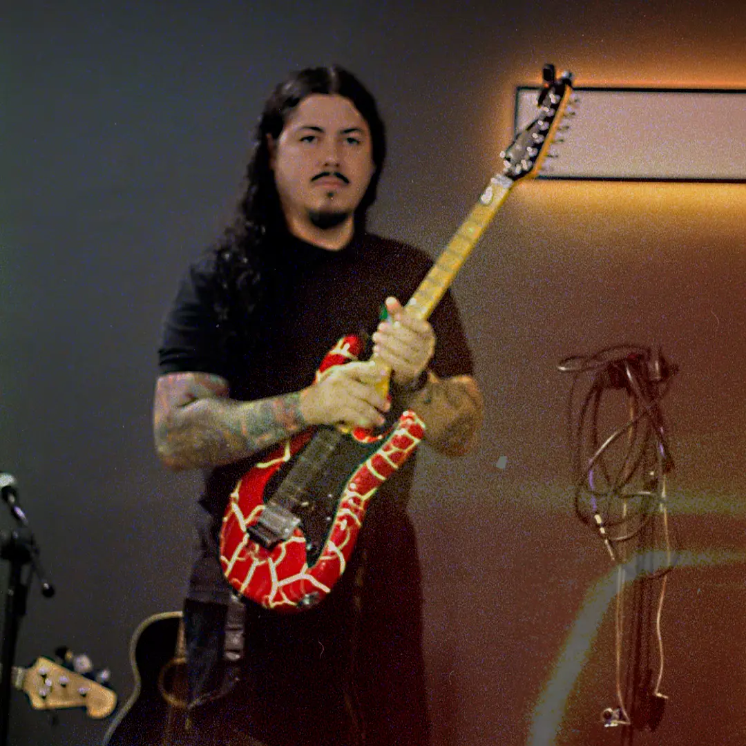 Guitarrista da ALLMEGA com guitarra vermelha