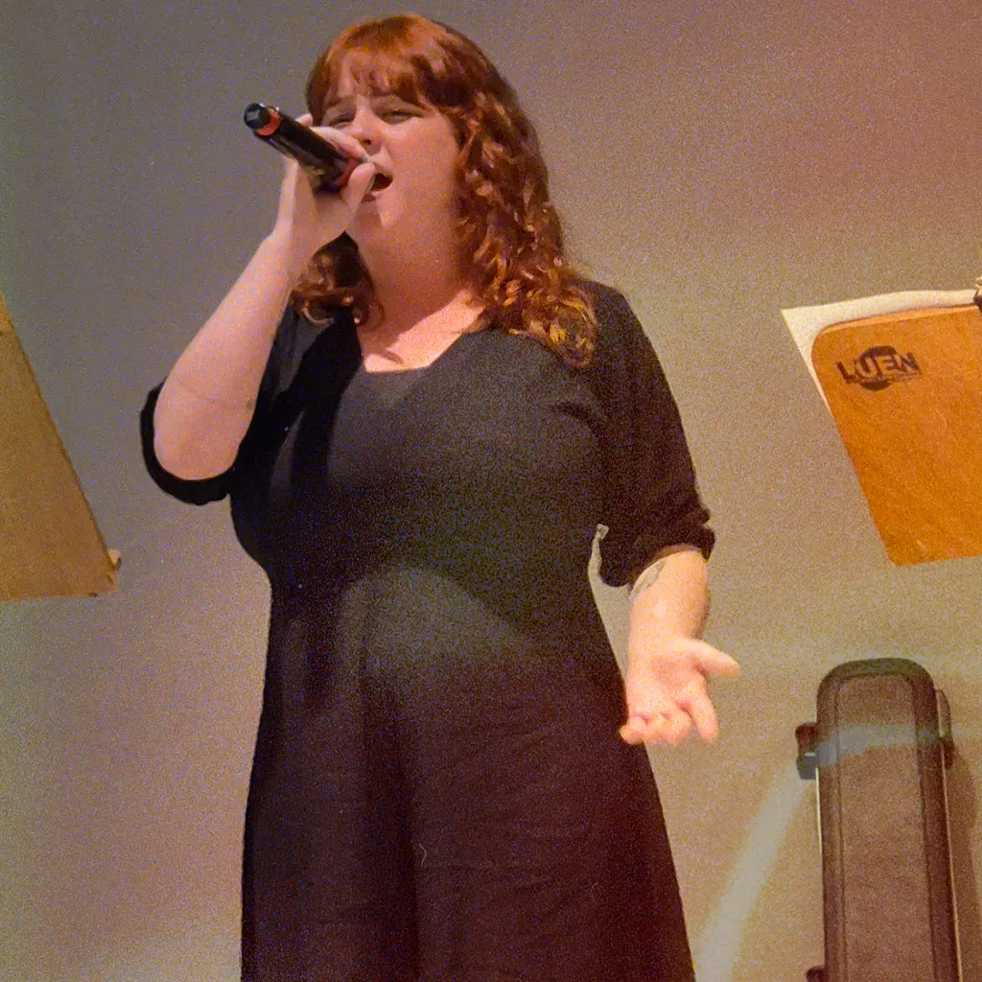 Vocalista da ALLMEGA cantando com microfone em mãos