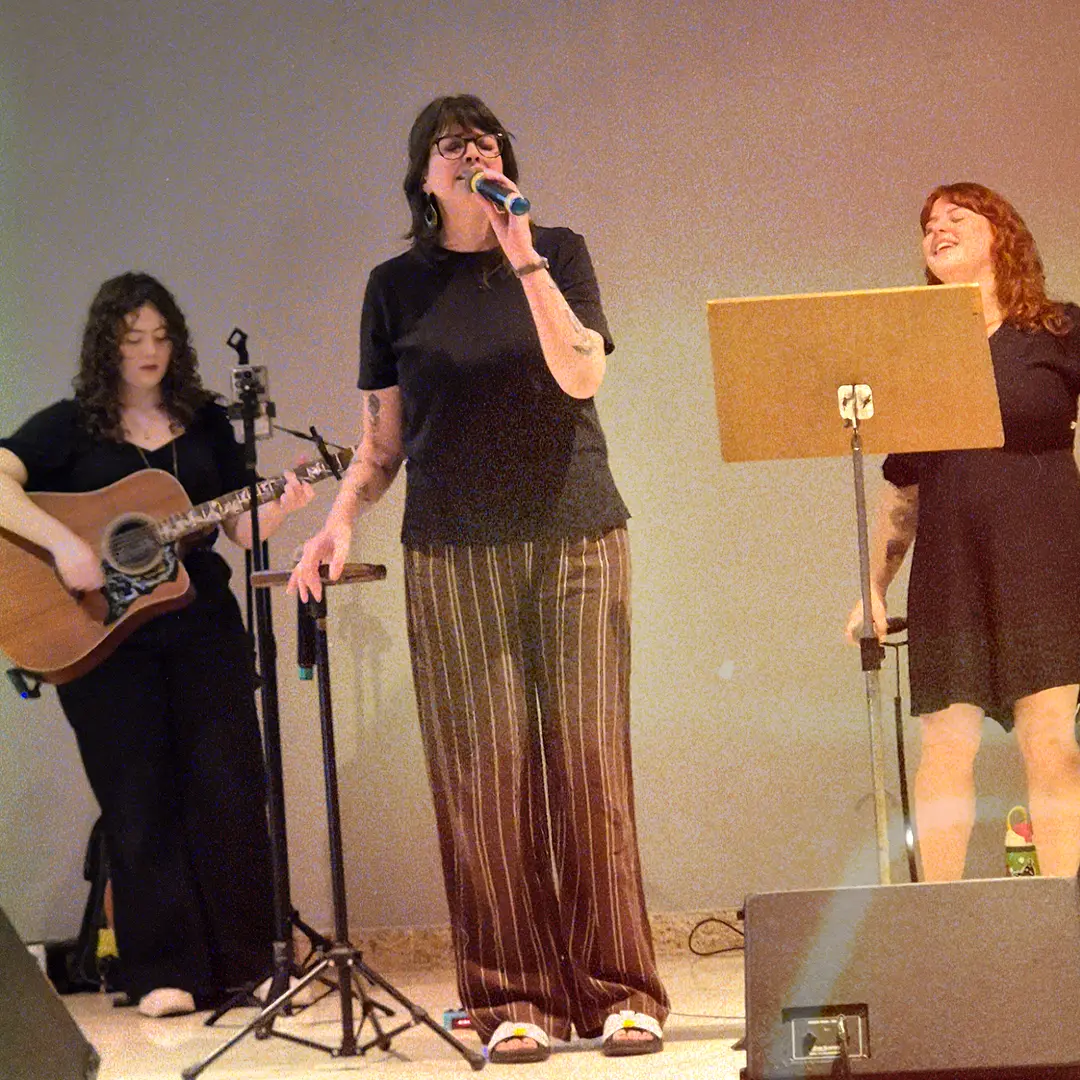 Vocalistas e violonista da ALLMEGA ministrando no palco