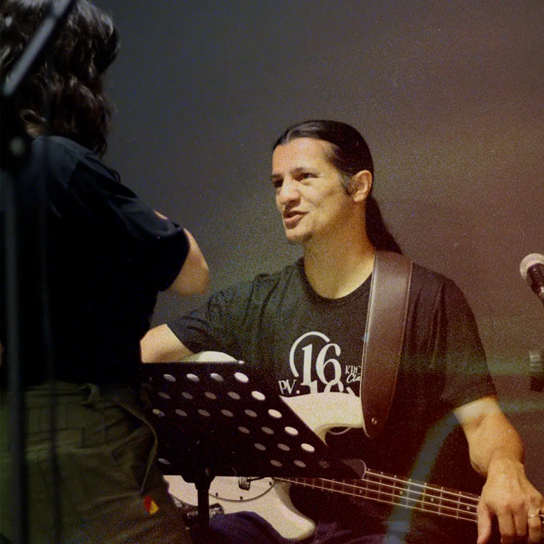 Baixista conversando com a banda antes do louvor
